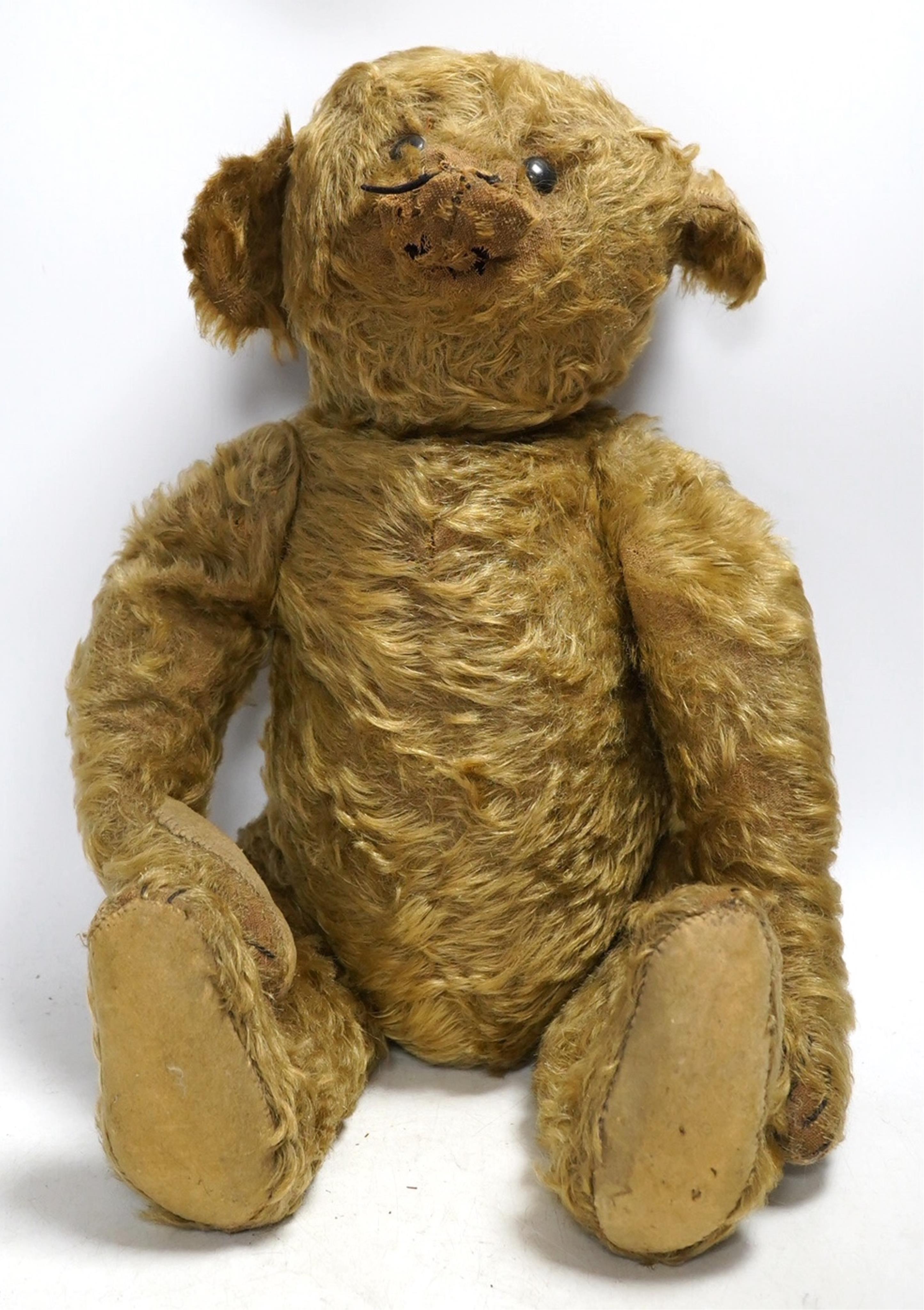 A Steiff gold plush teddy bear, c.1910, with boot-button eyes and hump-back, with button in left ear, circa 1910, 48cm. Condition - poor to fair